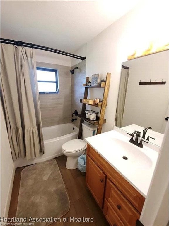 full bathroom featuring toilet, shower / tub combo with curtain, vanity, and wood finished floors