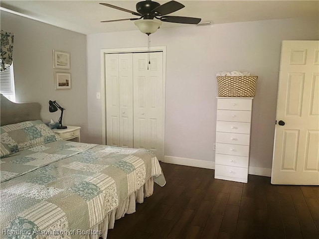 bedroom with dark wood-style flooring, a closet, baseboards, and ceiling fan