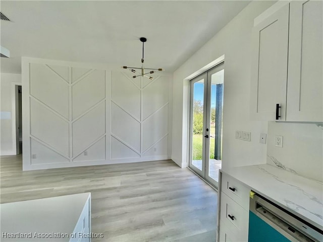 unfurnished dining area featuring french doors and light wood-type flooring