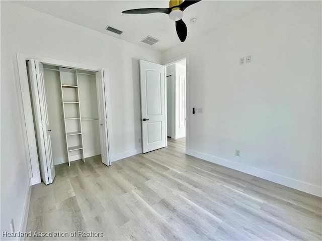 unfurnished bedroom with ceiling fan, light hardwood / wood-style flooring, and a closet