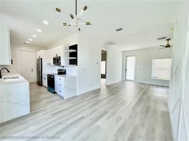 kitchen featuring light stone countertops, sink, white cabinetry, and stainless steel appliances