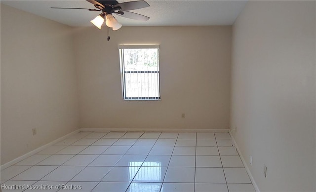 empty room with light tile patterned floors, ceiling fan, and baseboards