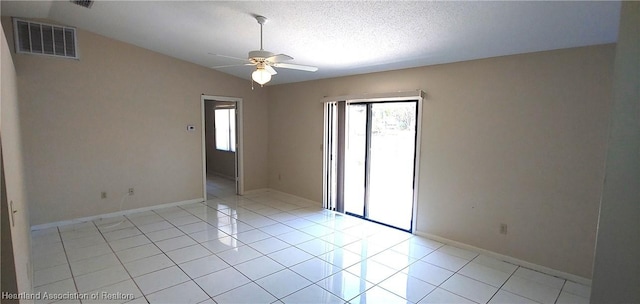 unfurnished room with light tile patterned floors, visible vents, a ceiling fan, vaulted ceiling, and a textured ceiling