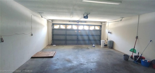 garage with concrete block wall and a garage door opener