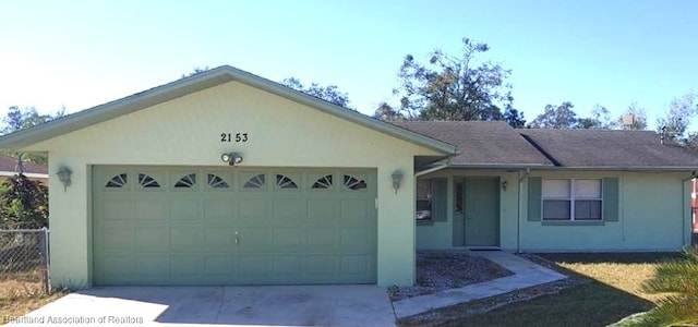 ranch-style house featuring a garage, driveway, and stucco siding