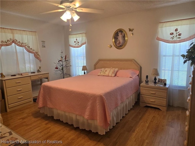 bedroom with light wood-type flooring, ceiling fan, and multiple windows