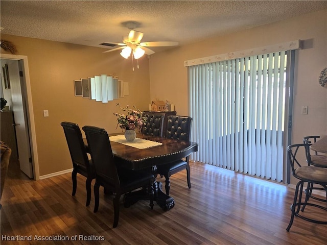 dining space with a textured ceiling, a ceiling fan, and wood finished floors