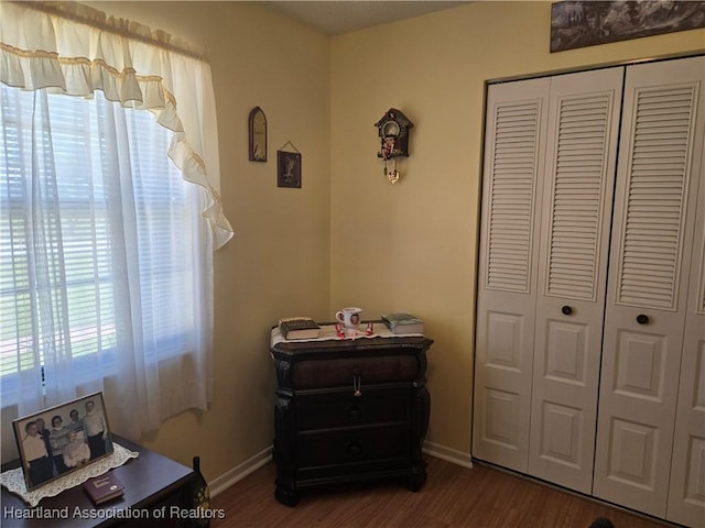 bedroom featuring a closet, baseboards, and dark wood finished floors