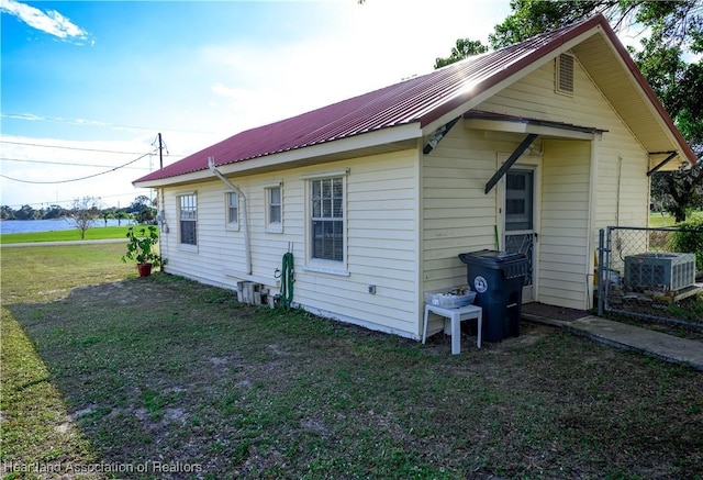 view of property exterior with central AC unit and a yard