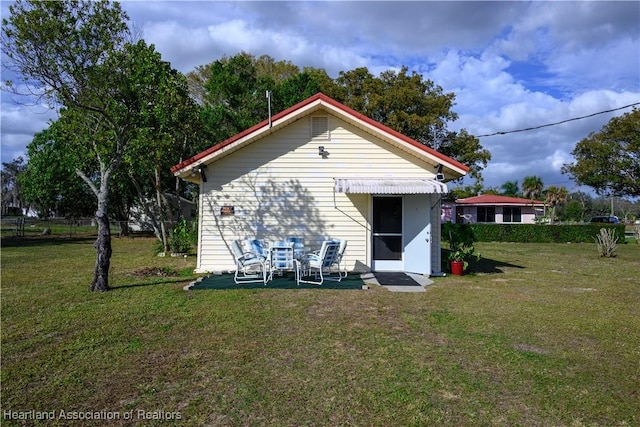 rear view of property featuring a yard