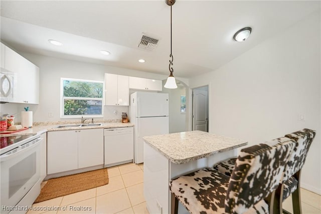 kitchen with white appliances, visible vents, decorative light fixtures, white cabinetry, and a sink