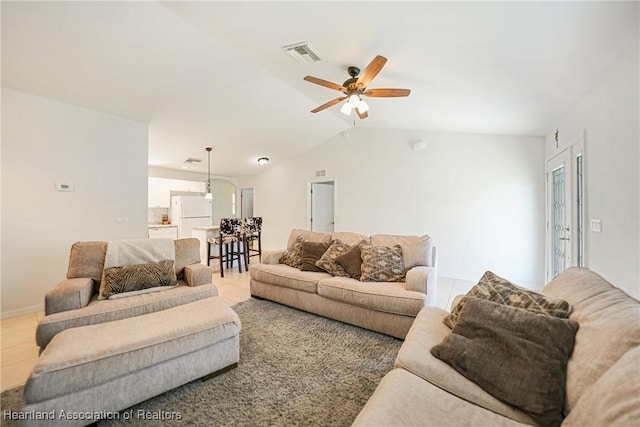 living room featuring lofted ceiling, tile patterned flooring, visible vents, baseboards, and a ceiling fan