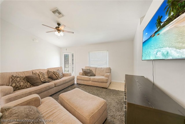 tiled living room featuring vaulted ceiling, visible vents, and a ceiling fan