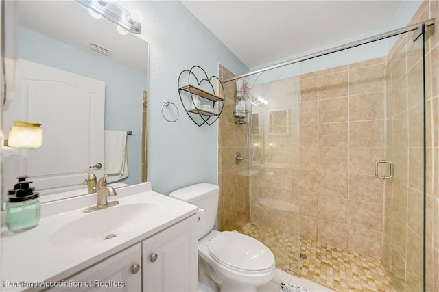 full bath with visible vents, a shower stall, toilet, and vanity