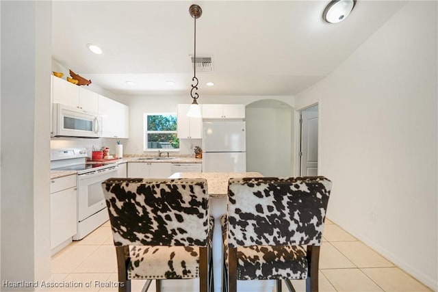 kitchen featuring light tile patterned flooring, white appliances, a sink, visible vents, and white cabinets