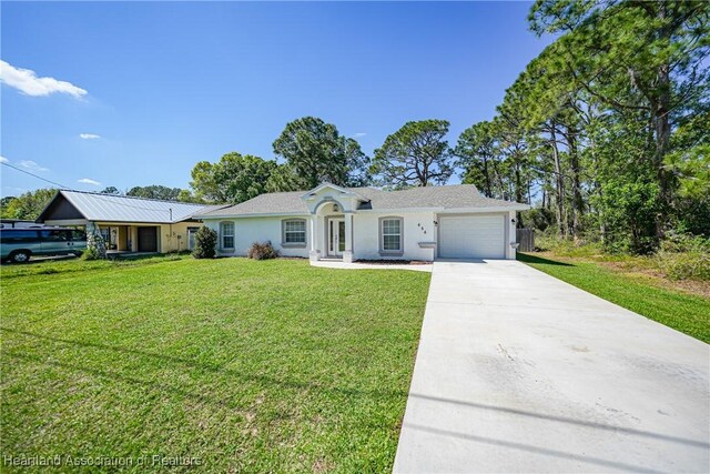 ranch-style home with driveway, a garage, a front yard, and stucco siding