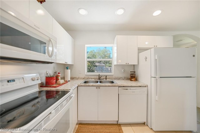 kitchen featuring light tile patterned floors, recessed lighting, white appliances, a sink, and white cabinets