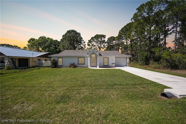 ranch-style home featuring concrete driveway, a lawn, an attached garage, and stucco siding