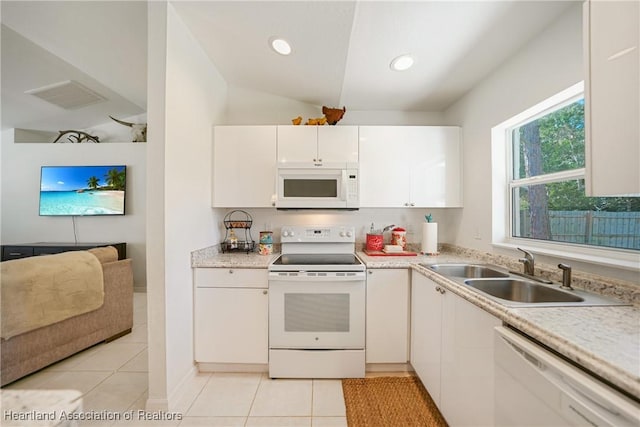 kitchen with light tile patterned floors, light countertops, visible vents, a sink, and white appliances