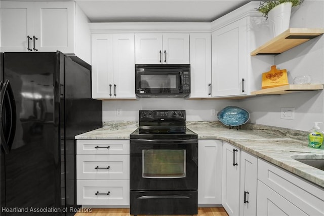 245 Lake Blvd, Sebring, FL 33875 - kitchen with black appliances, open shelves, white cabinets, and light stone countertops
