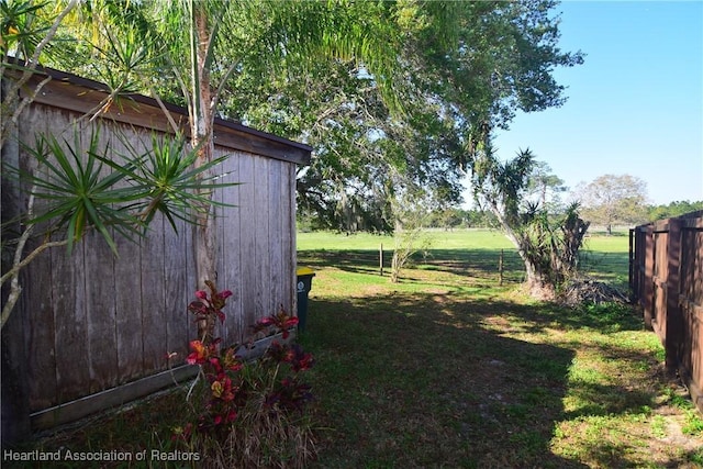 view of yard featuring an outdoor structure and fence