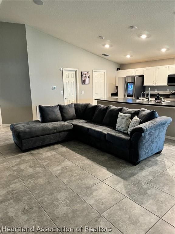 living room with sink and vaulted ceiling