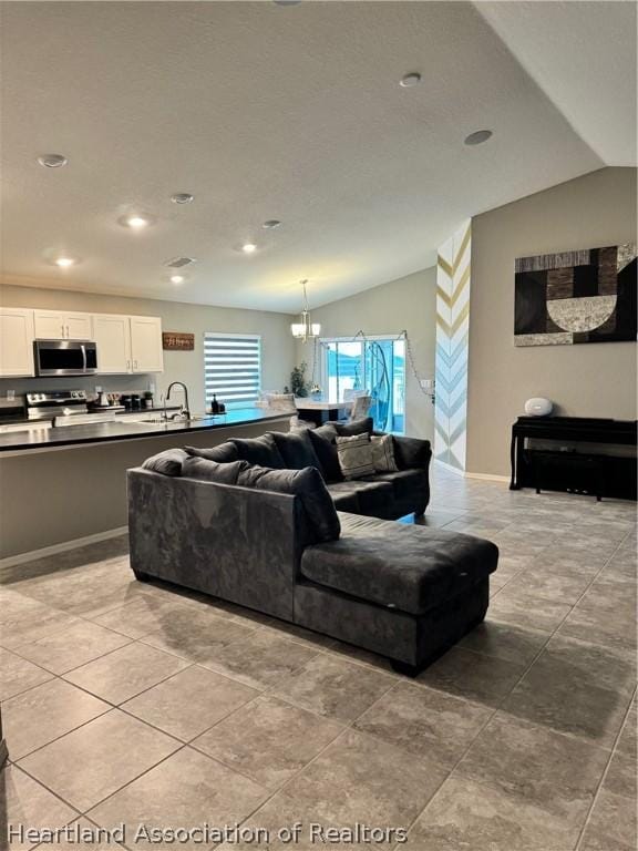 living room featuring lofted ceiling and an inviting chandelier