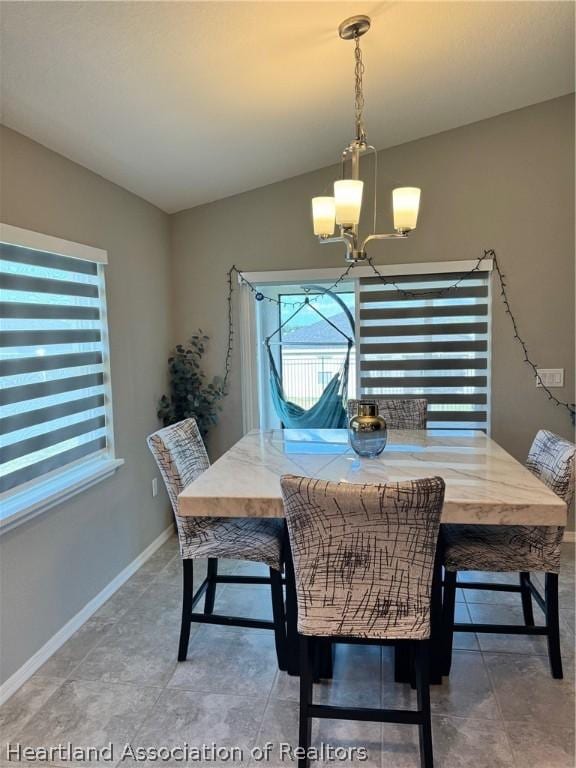 dining room with vaulted ceiling and an inviting chandelier