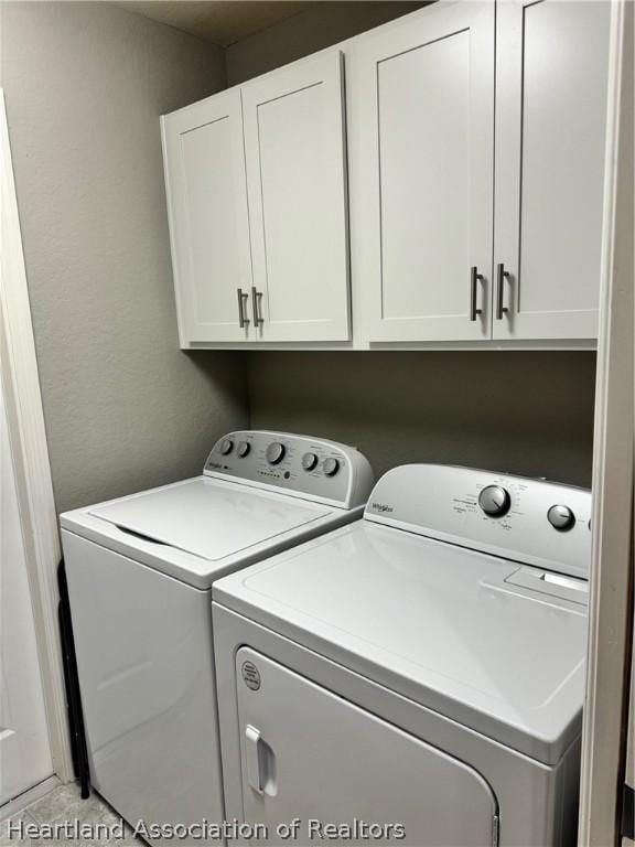 laundry room featuring cabinets and washing machine and dryer