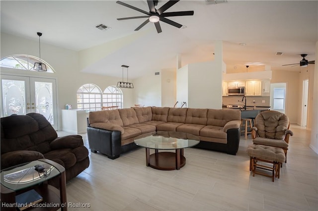 living area with french doors, visible vents, and ceiling fan