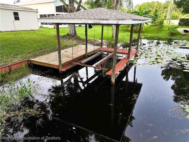 dock area with a lawn and a water view