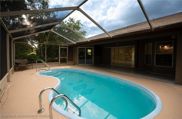 pool with a lanai and a patio area