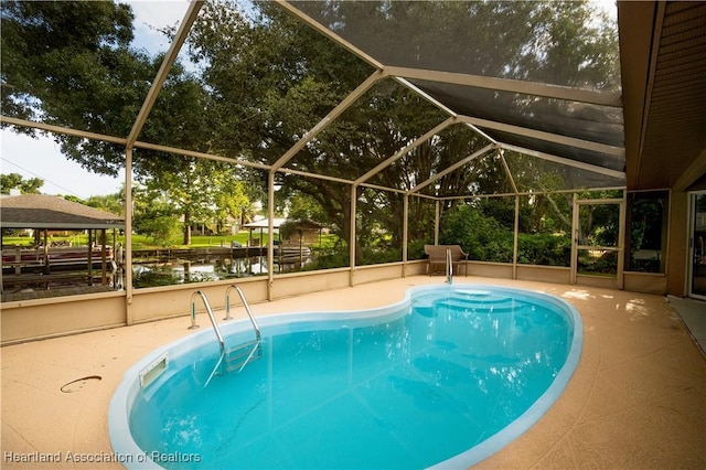 view of pool featuring a gazebo, glass enclosure, a patio area, and a water view