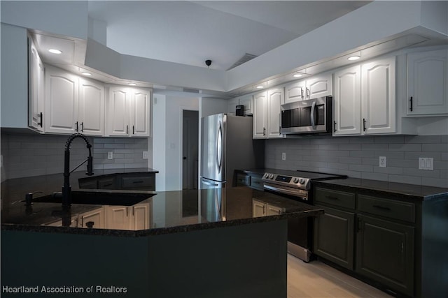 kitchen with white cabinets, stainless steel appliances, tasteful backsplash, and sink