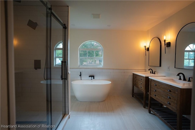 bathroom featuring vanity, tile walls, and independent shower and bath