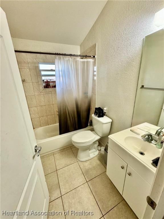 full bathroom featuring tile patterned flooring, shower / bath combo, toilet, and vanity