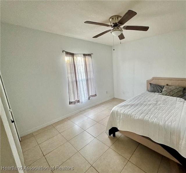 unfurnished bedroom featuring ceiling fan and light tile patterned floors