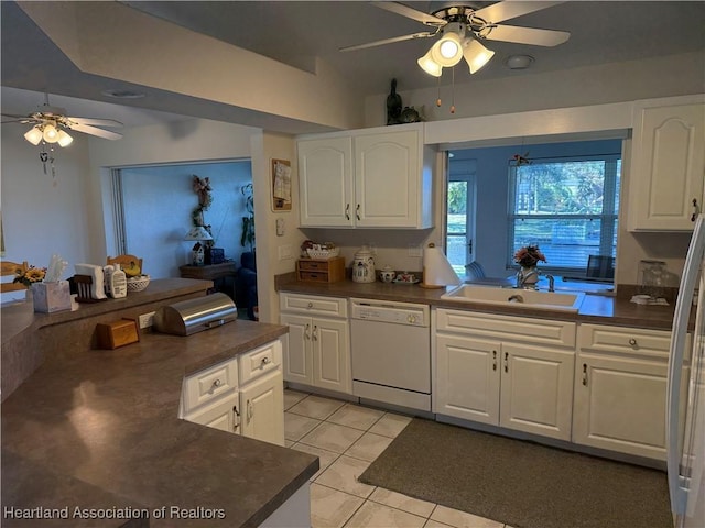 kitchen featuring white cabinets, dishwasher, light tile patterned floors, and sink