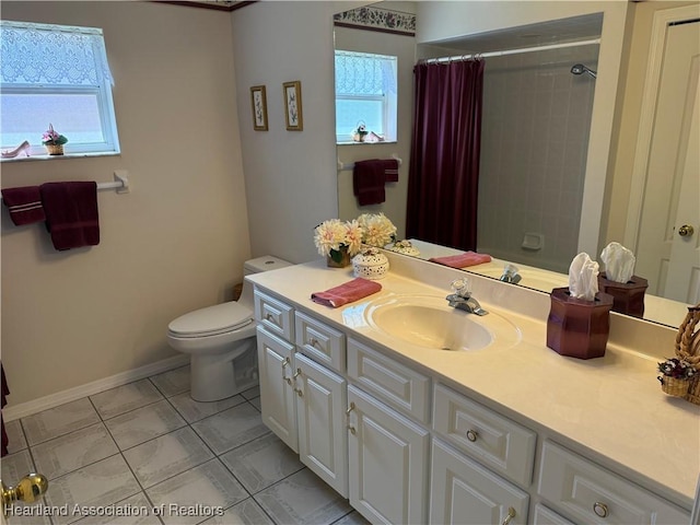 bathroom with tile patterned flooring, vanity, a healthy amount of sunlight, and toilet