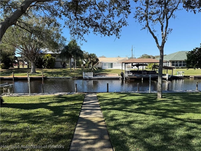 dock area with a lawn and a water view