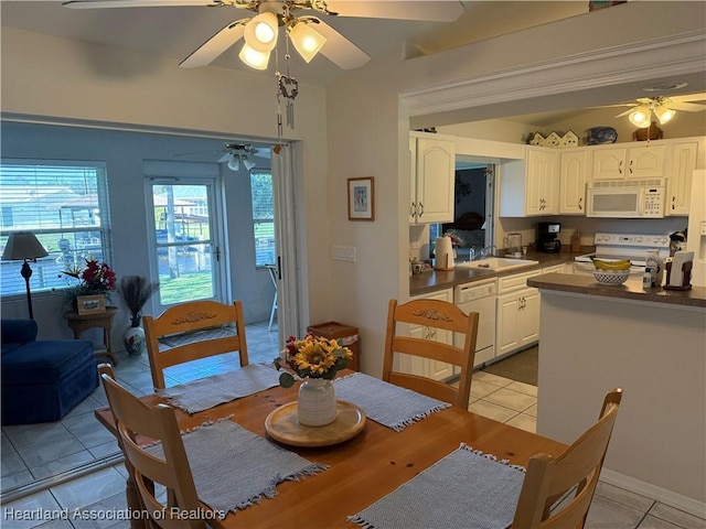 tiled dining space featuring ceiling fan and sink