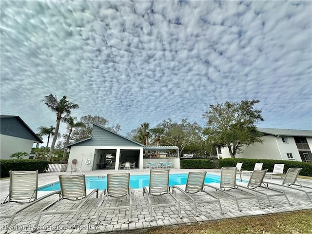 view of pool with a patio and an outdoor structure