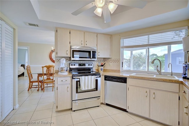 1712 Sunrise Pl, Sebring, FL 33870 - kitchen featuring appliances with stainless steel finishes, a tray ceiling, tasteful backsplash, light countertops, and light tile patterned flooring