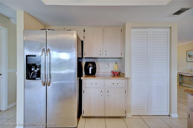 1712 Sunrise Pl, Sebring, FL 33870 - kitchen featuring stainless steel refrigerator with ice dispenser, light tile patterned floors, light countertops, and decorative backsplash