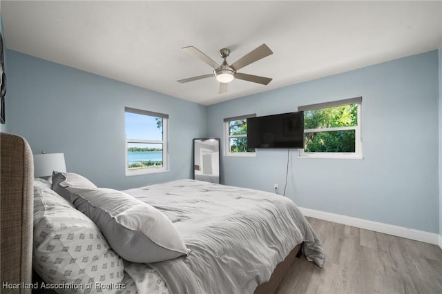 1622 Dinner Dr, Sebring, FL 33870 - bedroom with multiple windows, ceiling fan, baseboards, and wood finished floors