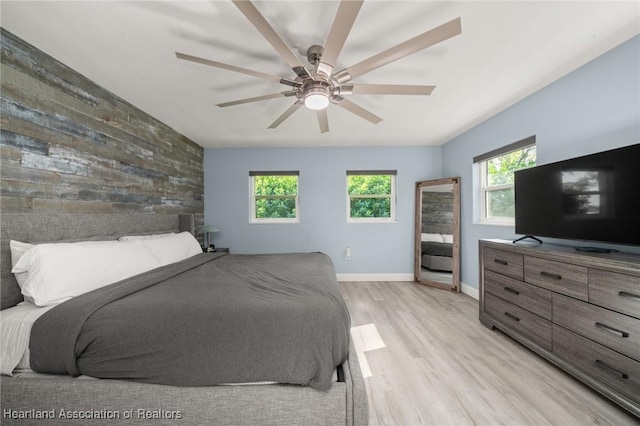 1622 Dinner Dr, Sebring, FL 33870 - bedroom with an accent wall, wooden walls, multiple windows, and light wood-type flooring