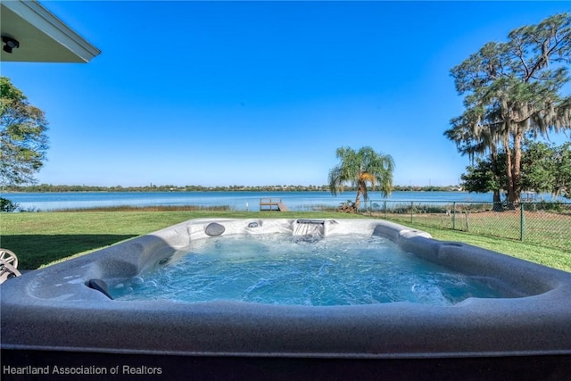 1622 Dinner Dr, Sebring, FL 33870 - view of swimming pool with a lawn, a hot tub, a water view, and fence
