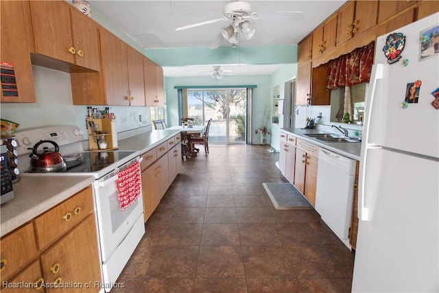 kitchen with sink, white appliances, ceiling fan, and dark tile patterned flooring