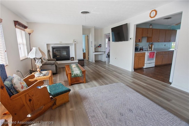 living room featuring a high end fireplace and light hardwood / wood-style floors