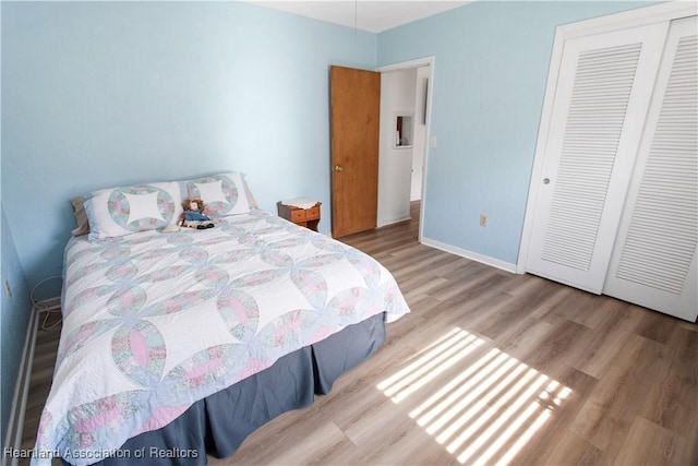 bedroom with light hardwood / wood-style floors and a closet